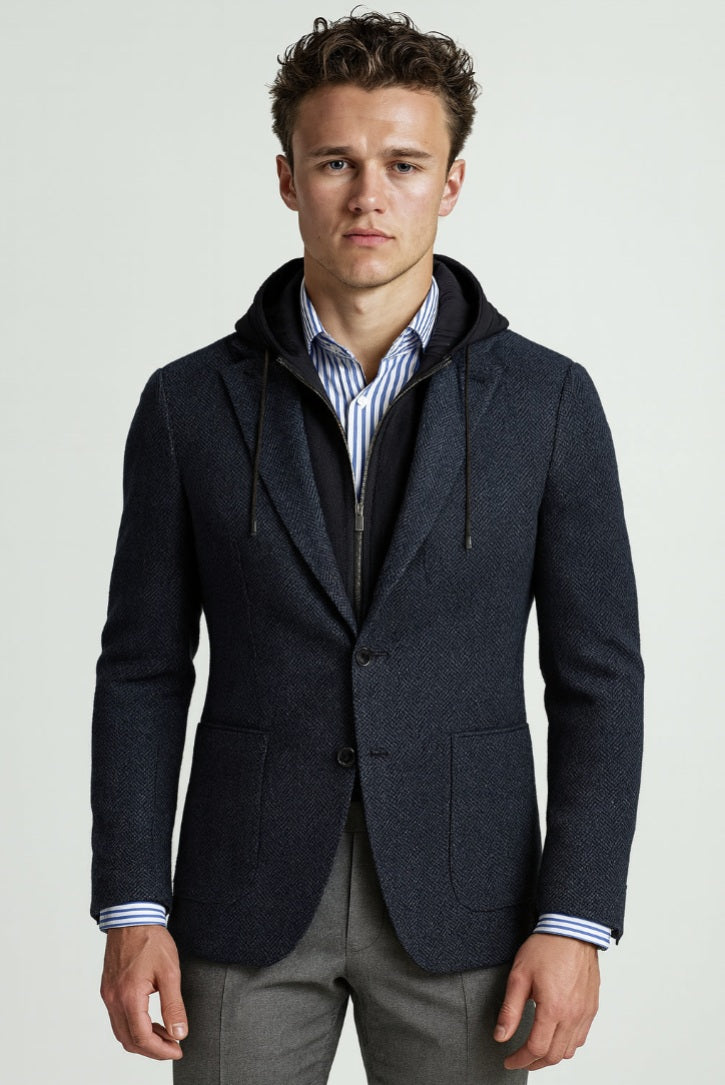 Man wearing a dark blue jacket with a hood on a light gray background