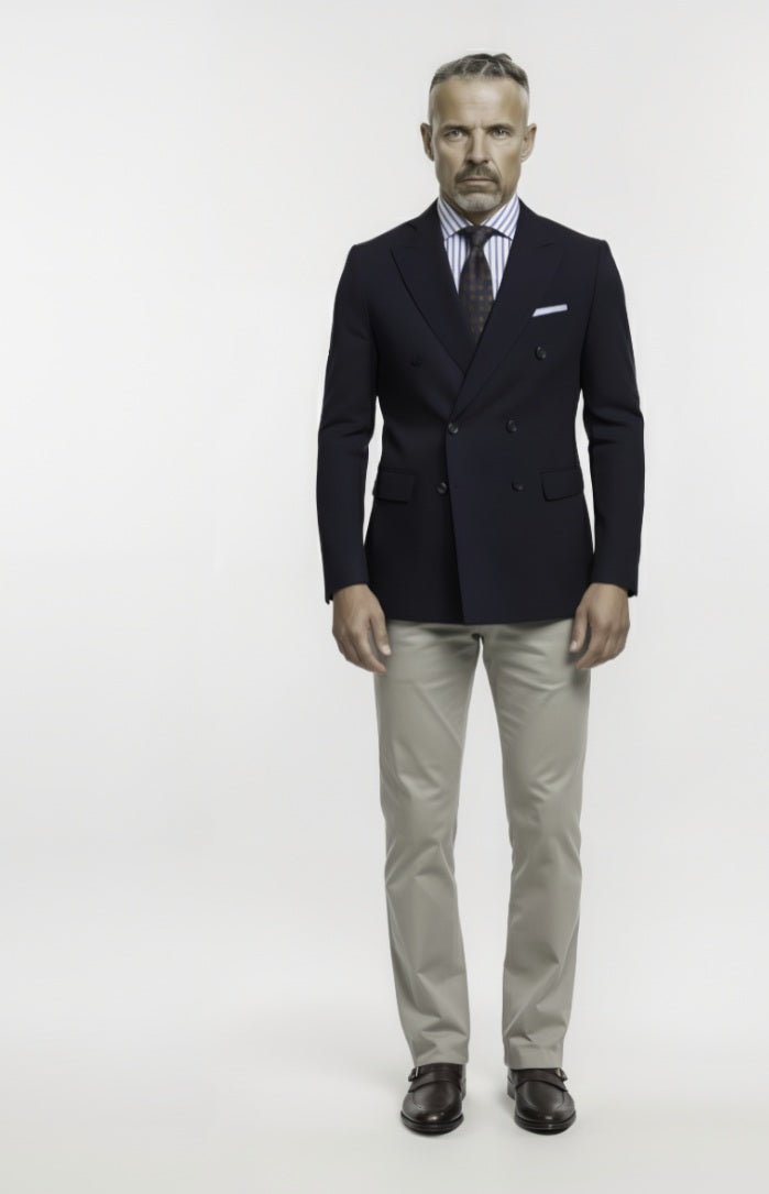 Man wearing a dark suit with a white shirt and striped tie on a white background