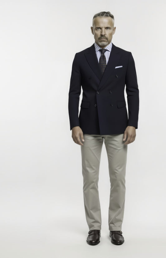 Man wearing a dark suit with a white shirt and striped tie on a white background