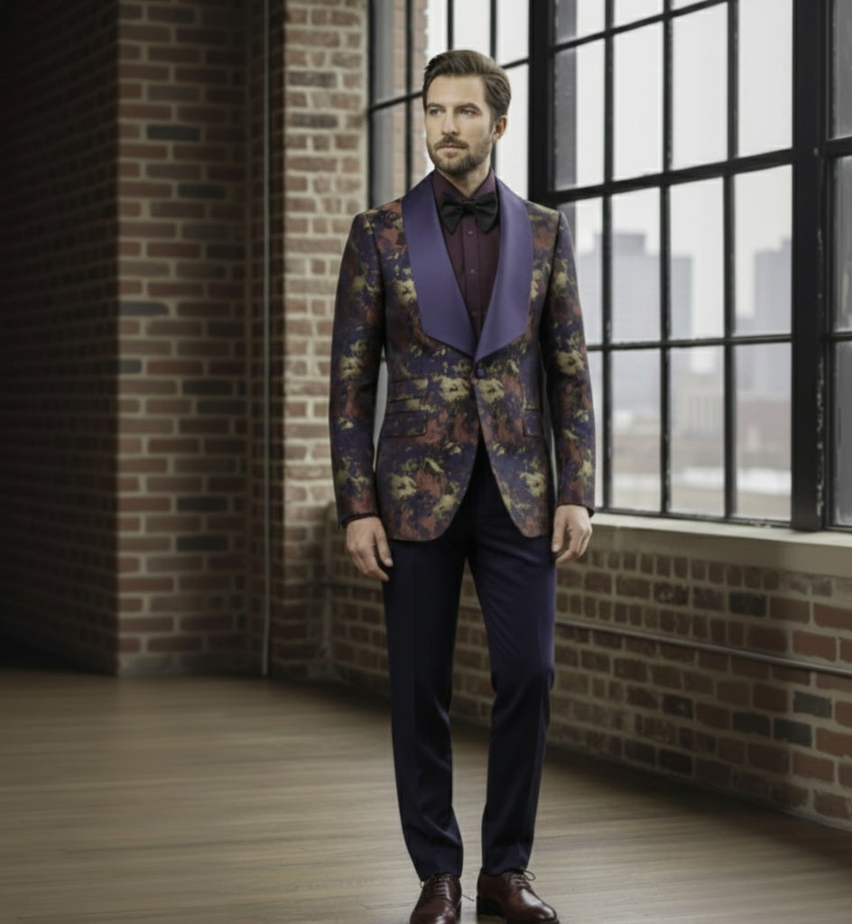 Man wearing a floral blazer with a purple lapel and bow tie in a room with brick walls and large windows.