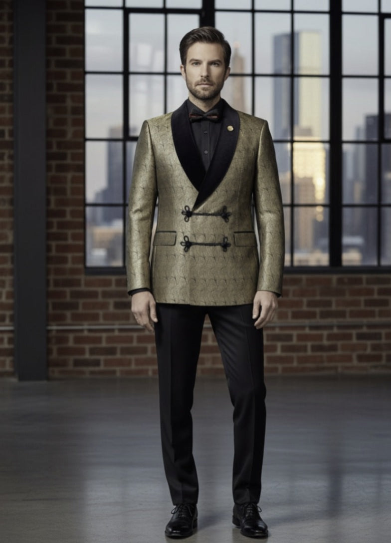 Man wearing a gold blazer and black pants standing in front of a large window with cityscape view.