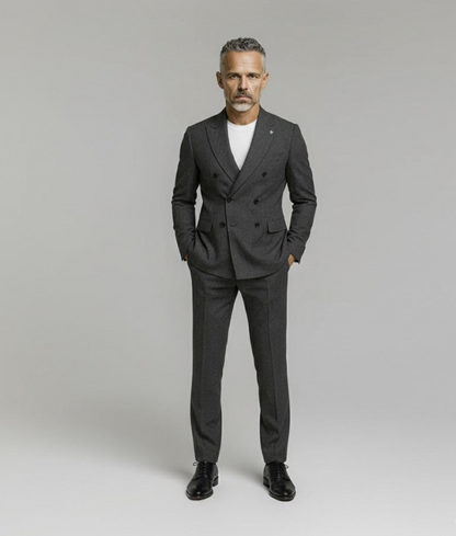 Man wearing a gray suit with a white shirt on a plain background