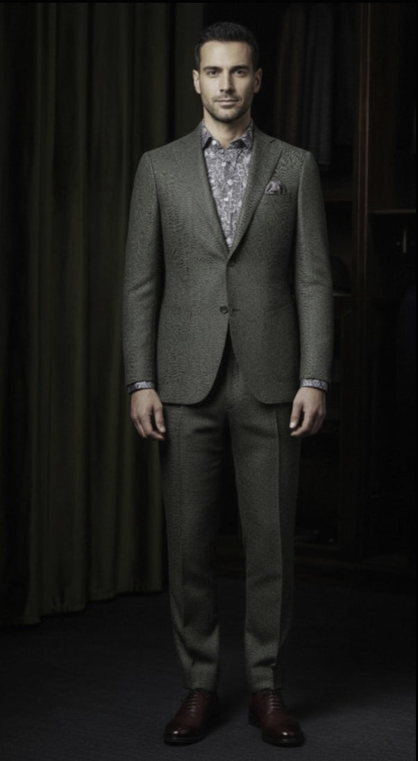 Man wearing a green Herringbone  suit with a patterned shirt against a dark background