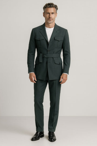 Man wearing a green safari suit with a white T-shirt on a plain background