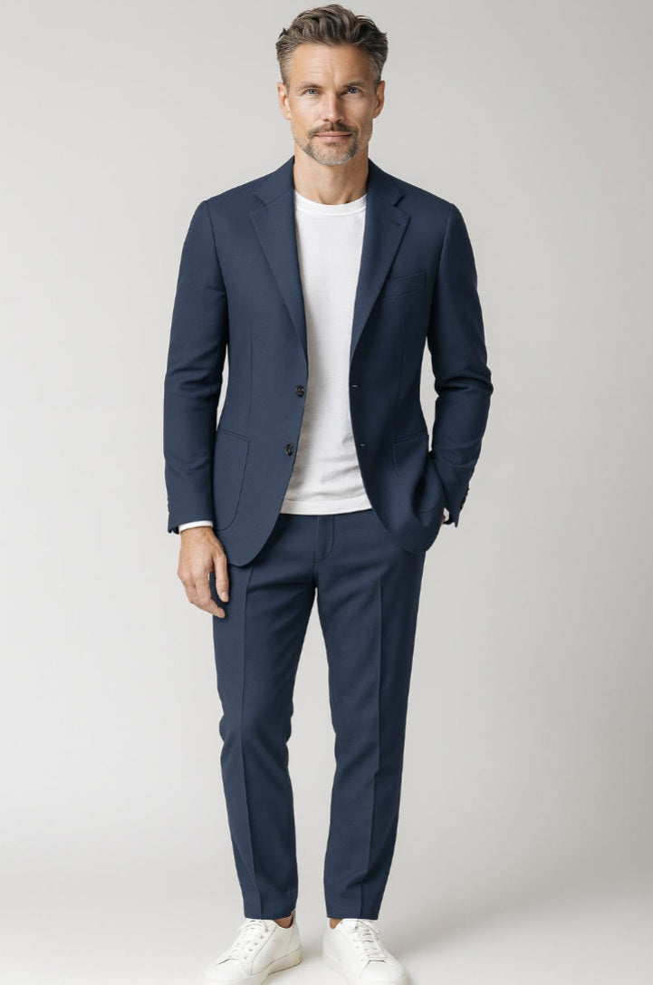 Man wearing a navy suit with a white shirt on a light grey background