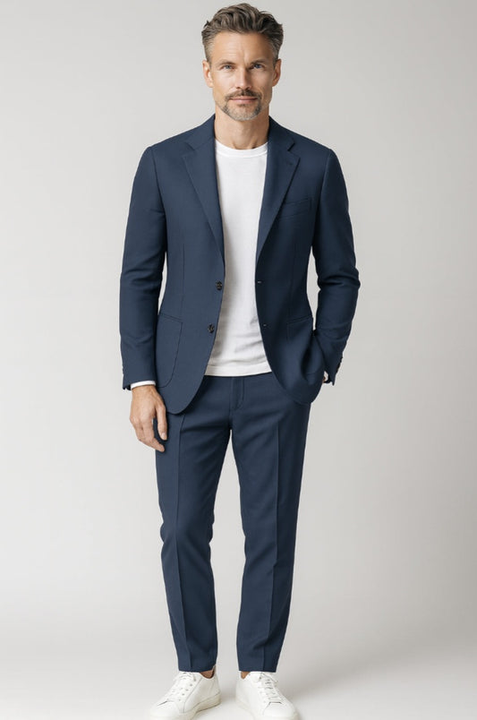 Man wearing a navy suit with a white shirt on a light grey background