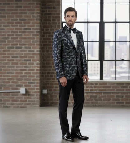 Man_wearing_a_patterned_blazer_and_black_pants_in_an_industrial-style_room_with_brick_walls_and_large_windows