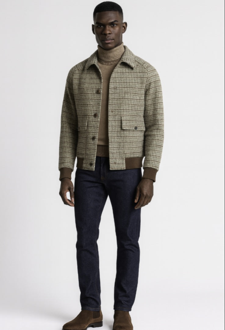 Man wearing a plaid shirt over a sweater with dark pants on a white background