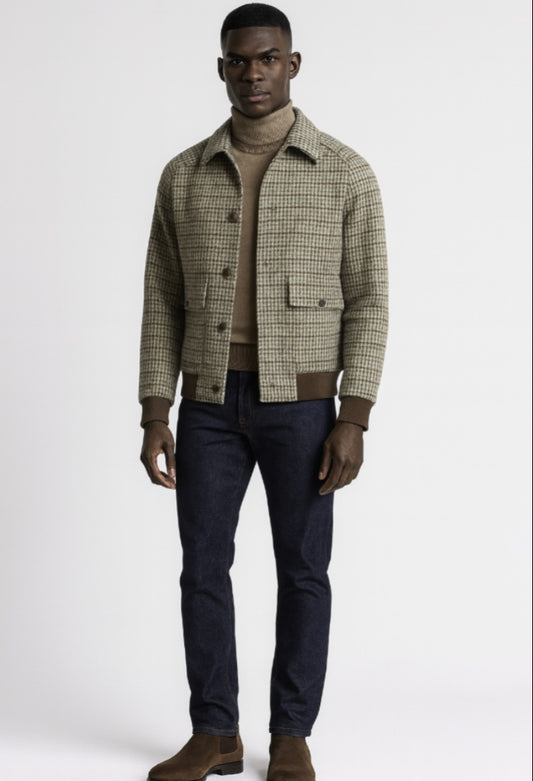 Man wearing a plaid shirt over a sweater with dark pants on a white background