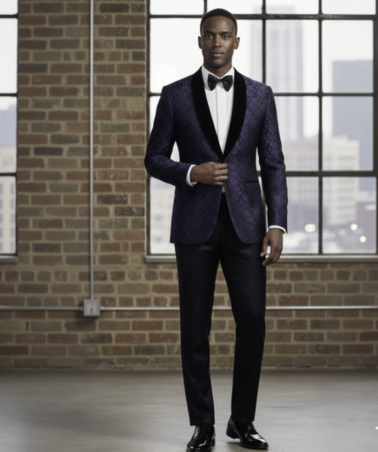 Man wearing a purple suit with a black bow tie in front of a brick wall