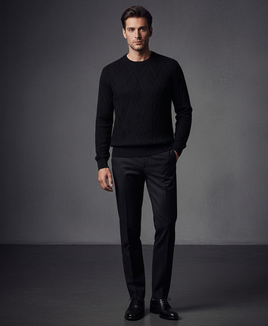 Man wearing a black sweater and pants against a gray background