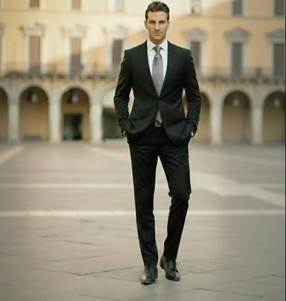 Man in a black suit standing in an open square with classical architecture.