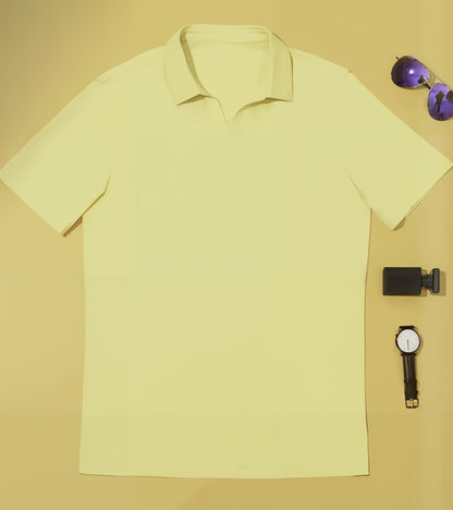 Yellow polo shirt with sunglasses and watch on a beige background