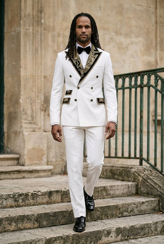 A man wearing a white double-breasted suit with ornate black and gold patterned lapels and pocket flaps, walking down stone steps outdoors.