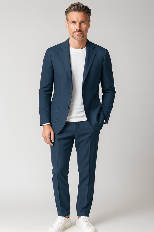 Man wearing a navy suit with a white shirt on a light gray background