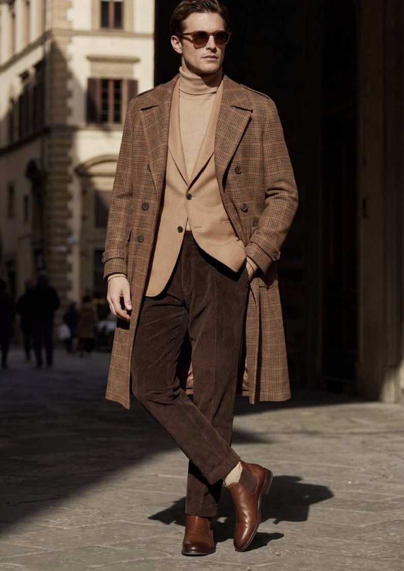 The statement brown check wool overcoat features a distinctive heritage-inspired check, peak lapels, double-breasted styling and a beautifully tailored silhouette. Layered underneath is a luxurious camel-toned waistcoat, creating an elegant contrast against the deep brown corduroy trousers.

Finished with polished brown leather Chelsea boots, this look is ideal for autumn and winter occasions, country weekends, business dressing, weddings and sophisticated everyday wear.