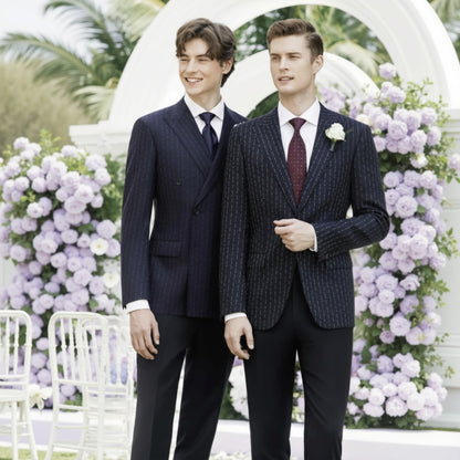 Two men in suits standing in front of a floral archway.
