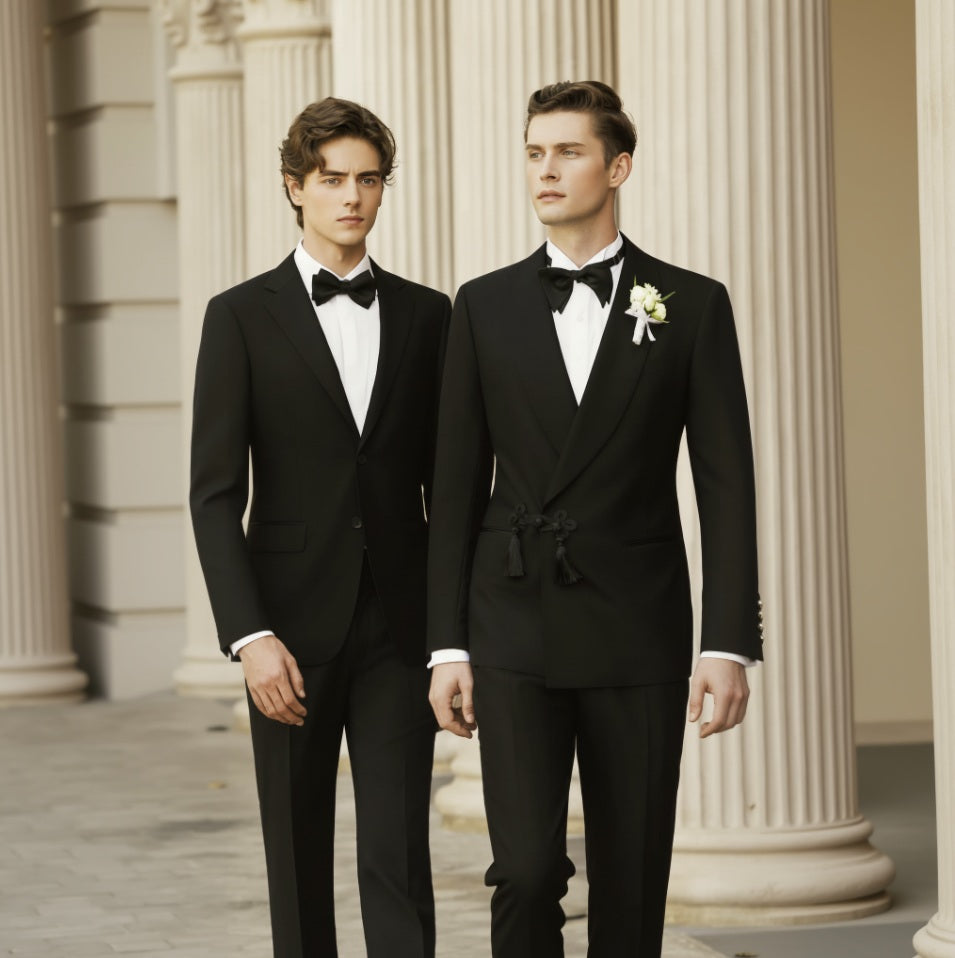 Two men wearing black double-breasted suits and bow ties, standing in a columned hallway.