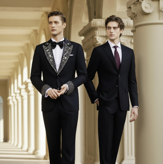 Two men wearing black tuxedos with white brocade lapels, single-breasted jackets, and bow ties, standing in a columned hallway.