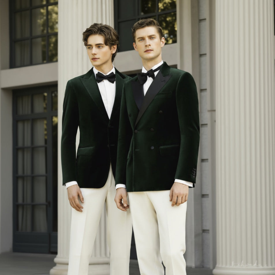 Two men wearing green velvet double-breasted evening jackets with black satin peaked lapels and white trousers, standing in front of a columned building.