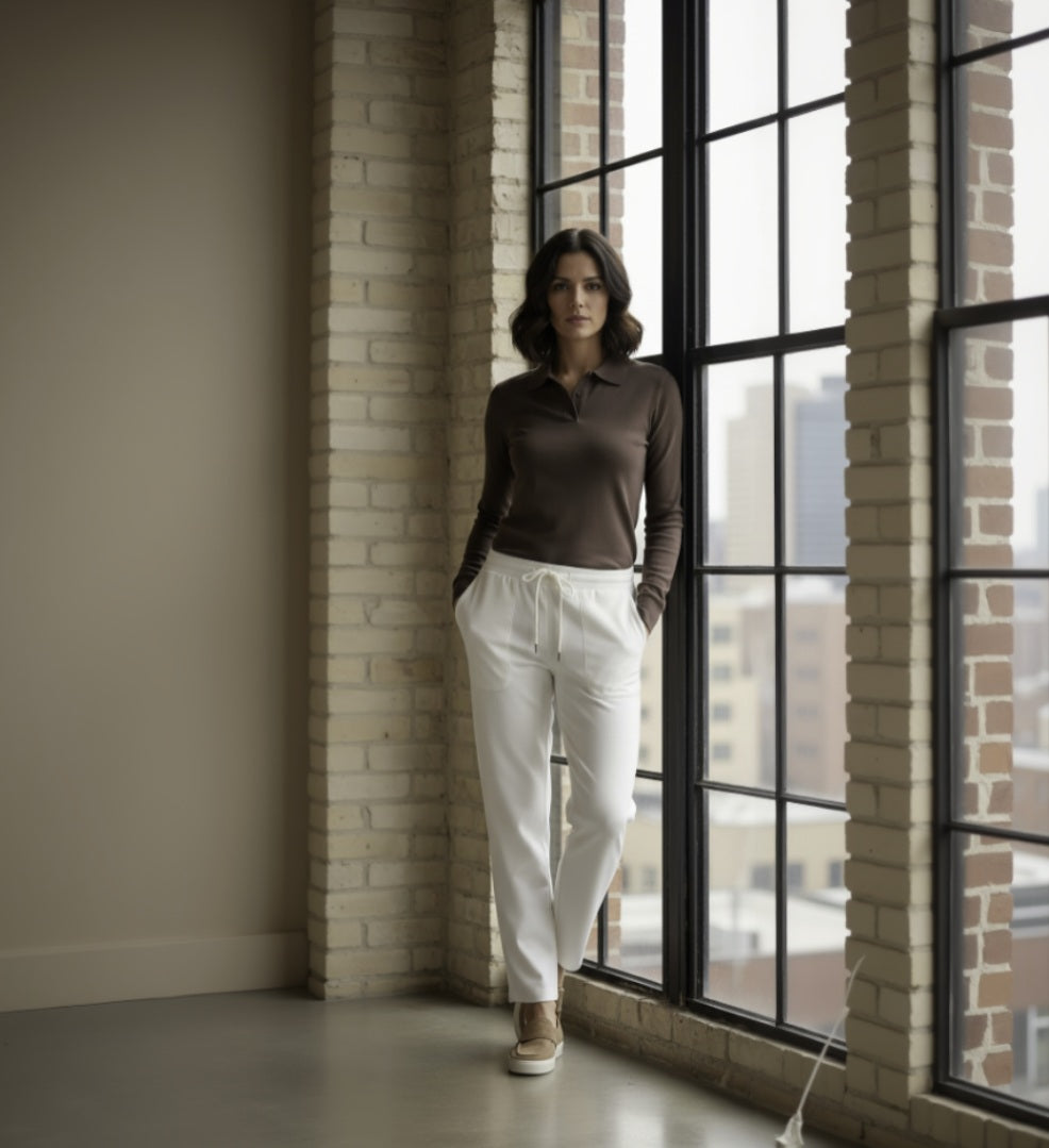 Woman standing by a large window in an urban setting