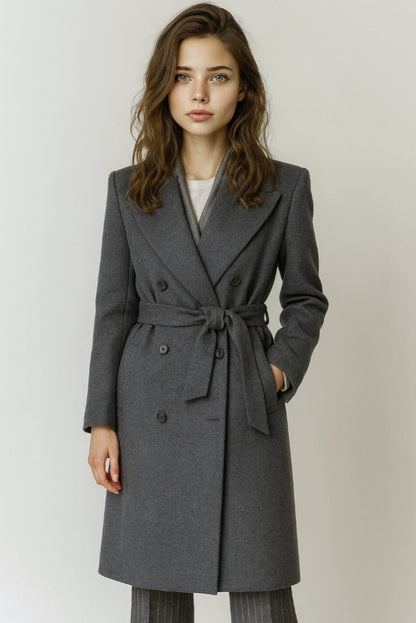 Woman wearing a grey coat on a plain background