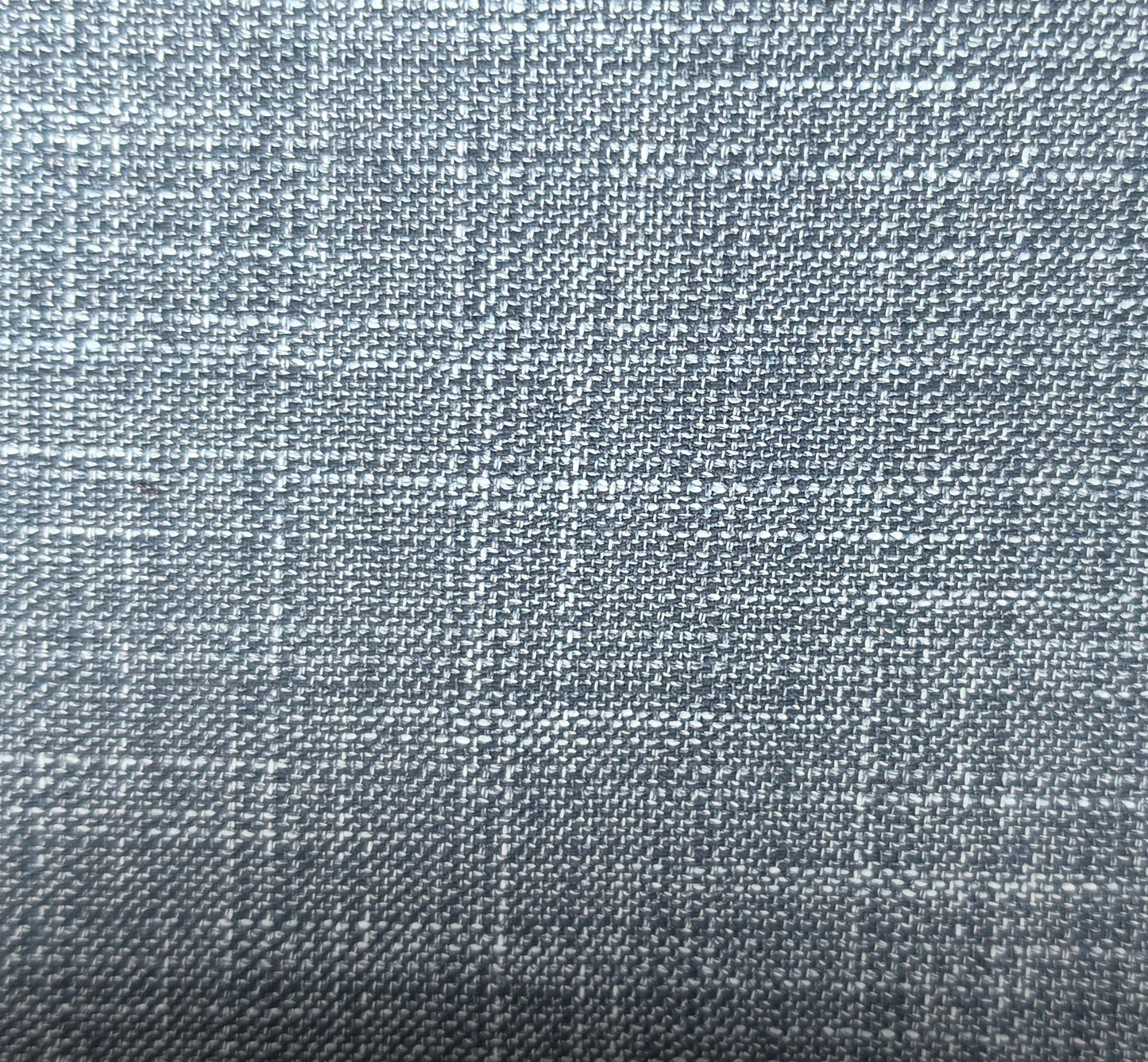A close-up of a woven fabric texture in a cool grayish blue color with subtle white and darker gray threads.