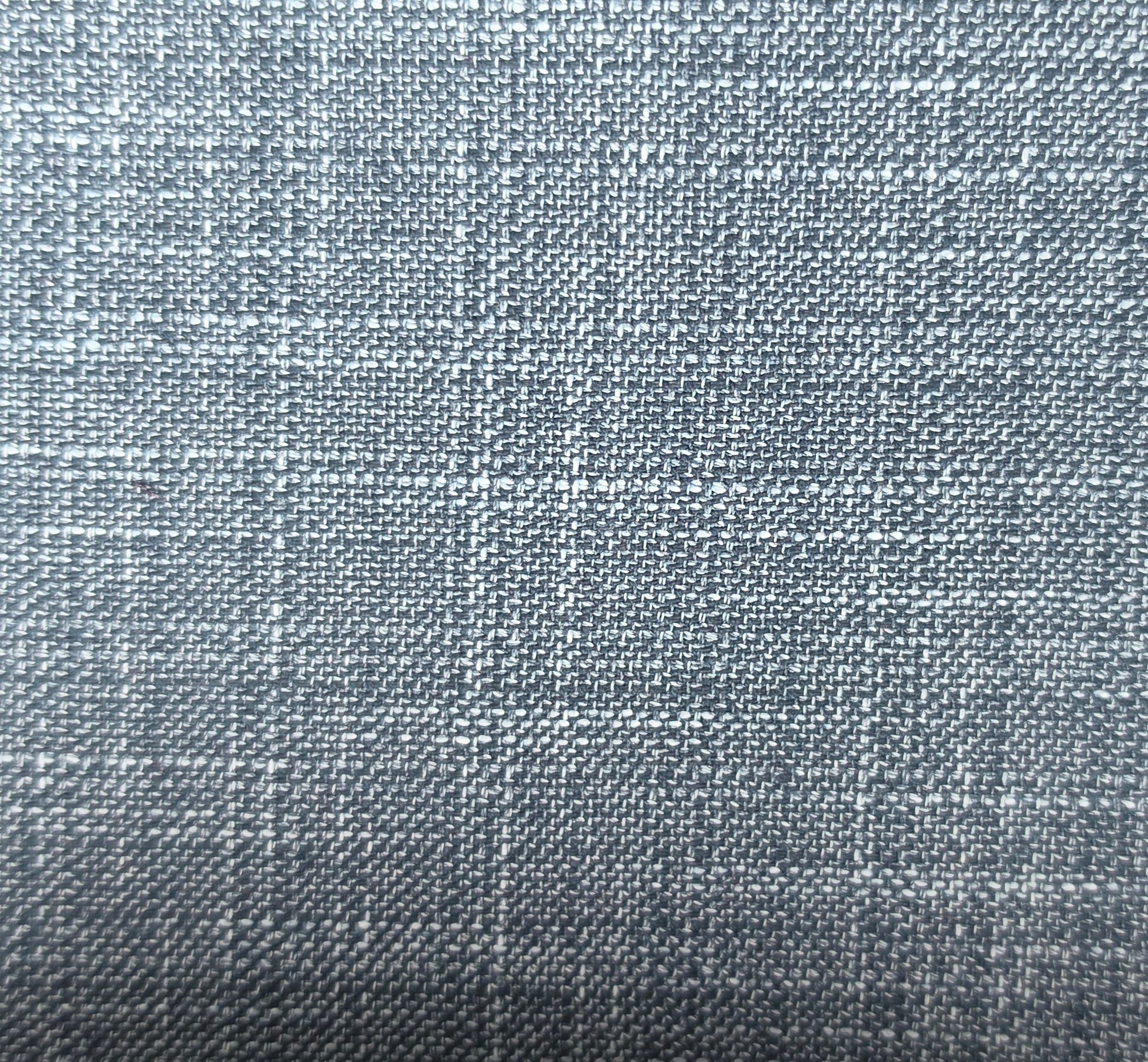 A close-up of a woven fabric texture in a cool grayish blue color with subtle white and darker gray threads.