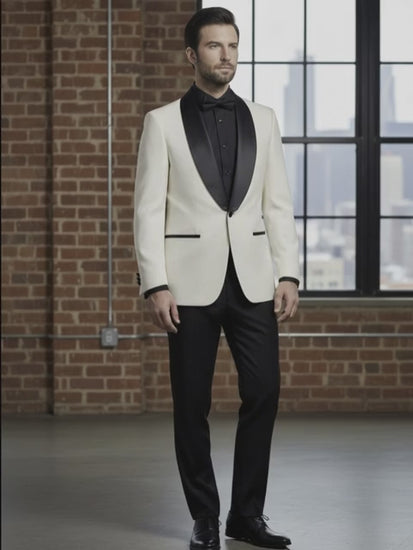 Man wearing a white tuxedo with black lapels in an urban setting.